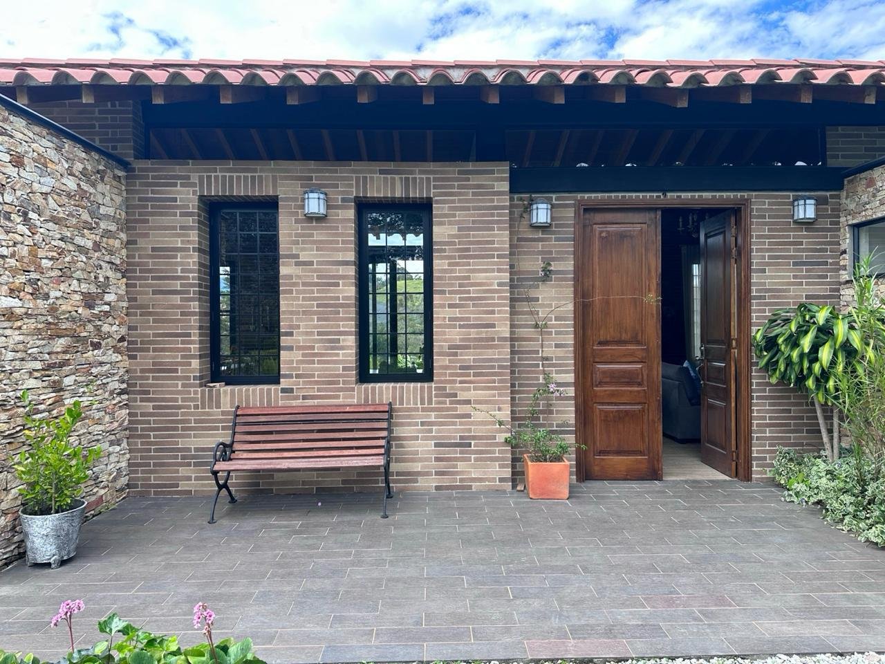 Entrada con puerta doble en madera y banca